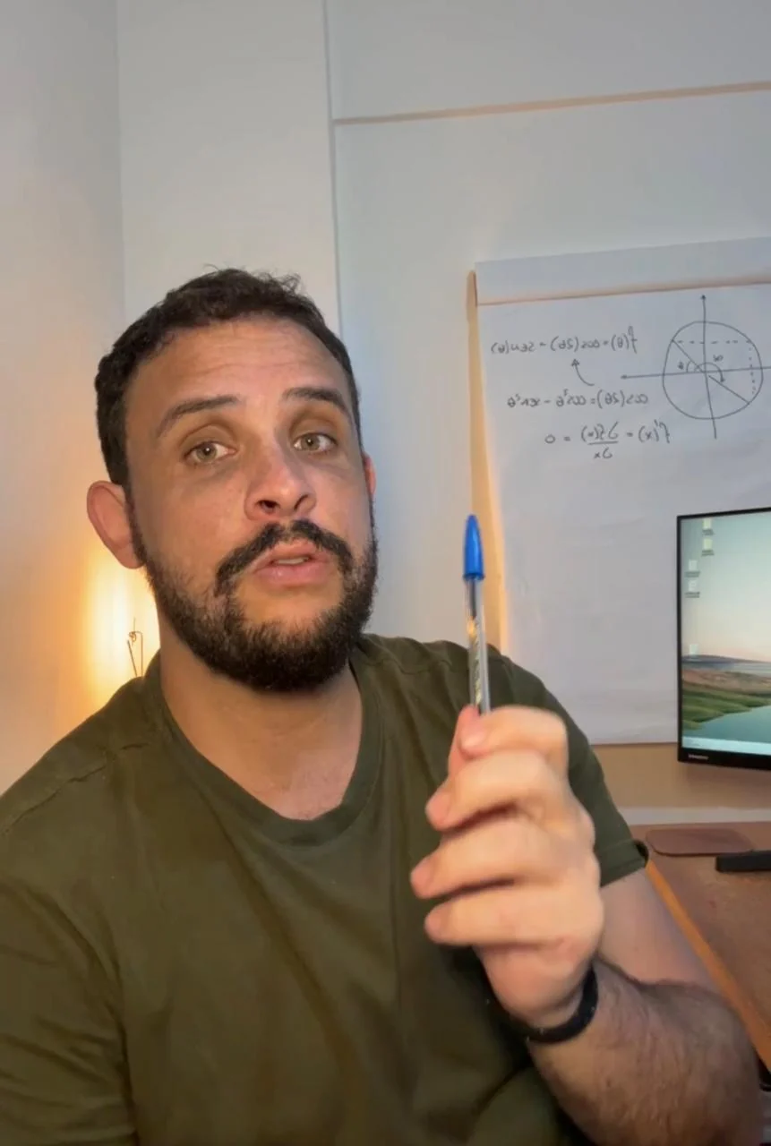 Professor Guilherme explicando, com um quadro de trigonometria e derivadas ao fundo